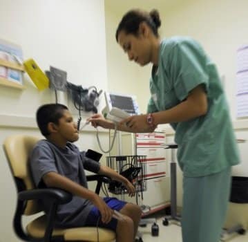 Enfermera haciendo el ingreso de un niño a la cita médica